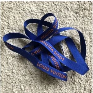 Authentic Louise Vuitton Blue ribbon with rusty orange logo .